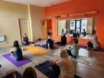 Sesión de yoga en el interior del Wellness Barn con participantes en esterillas