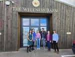 Fachada exterior del The Wellness Barn con grupo de personas frente a la entrada