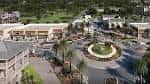 Plaza central con rotonda paisajística y accesos a tiendas del distrito comercial