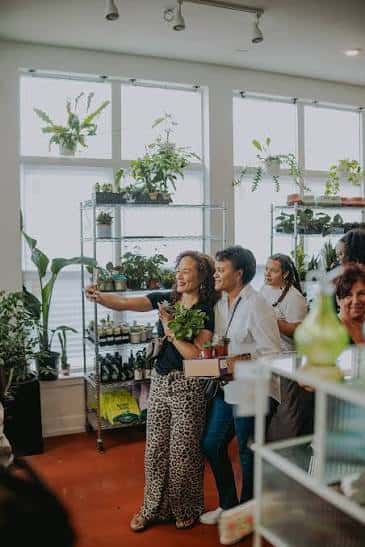 Grupo de personas disfrutando de un evento en el interior del local con plantas