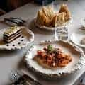 Mesa servida con platos de comida italiana en Mina Ristorante Siciliano
