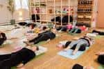 Clase de yoga en grupo sobre esterillas en un salón luminoso