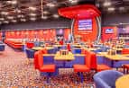 Interior del salón de bingo con mesas y sillas de colores