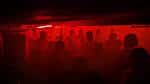 Vista interior del club con iluminación roja y público