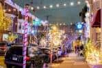 Calle decorada con luces festivas y árboles iluminados durante la noche