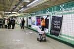 Andén de la estación con arte público en las paredes y personas caminando