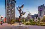 Plaza exterior con escultura y edificios del Grand Center Inc.