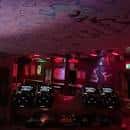 Plataforma de DJ en el interior del bar con iluminación roja