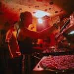 DJ actuando en la cabina con iluminación cálida