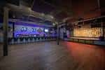 Interior del salón de eventos HI-FI con barra y escenario vacío