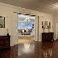 Interior elegante con suelo de madera pulida y puerta abierta hacia sala iluminada