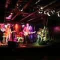 Concierto en vivo en el interior del Drunken Unicorn con banda en el escenario