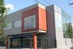 Exterior moderno del Centro de Salud Esperanza con fachada de vidrio y paneles rojos