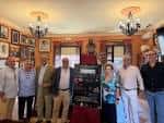 Interior del local cultural con grupo de personas reunidas, decoración tradicional y lámparas colgantes