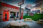 Vista exterior de la fachada del Red Door Tavern con su característica puerta roja y zona de picnic