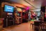 Interior del Four Quarters Arcade Bar con máquinas recreativas y ambiente nocturno