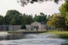 Lago con fuente y edificios históricos rodeados de vegetación en Washington Park