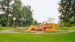 Área de juegos infantiles en el parque con columpios y toboganes amarillos
