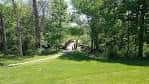 Sendero arbolado dentro de Brookside Park con puente de madera al fondo