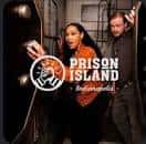 Dos personas en una escena temática de prisión con el logo de Prison Island Indianapolis