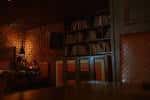 Área acogedora del lounge con estanterías de libros y iluminación cálida