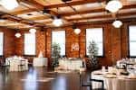 Sala de eventos interior con techos altos y vigas de madera expuestas