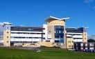 Fachada del complejo hospitalario con arquitectura contemporánea bajo cielo despejado