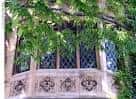 Detalle arquitectónico de una ventana con vidrieras y elementos ornamentales en la fachada