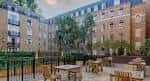 Terraza exterior con mesas y sillas rodeada de edificios residenciales