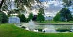 Vista panorámica del parque con estanque y fuentes en primer plano