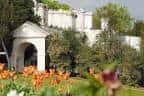 Fachada clásica del edificio principal rodeado de jardines floridos