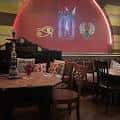 Interior del Egyptian Cafe & Hookah Bar con decoración temática egipcia y mesa de hookah