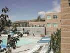 Piscina exterior del centro comunitario con tumbonas y edificios alrededor