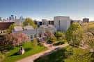 Vista exterior del campus con jardines, senderos y edificios blancos bajo cielo despejado