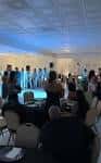 Evento en curso con invitados sentados y ambiente festivo