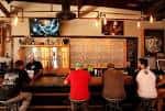 Interior del taproom con barra de cerveza y clientes sentados