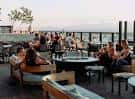 Terraza exterior con mesas y personas disfrutando de la vista
