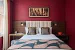 Habitación estándar con cama doble y paredes en tono rojo intenso