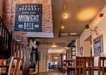Interior del pub The Midnight Bell con barra y decoración rústica
