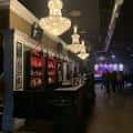 Bar interior del Metro Music Hall con lámparas colgantes y pantalla de fondo
