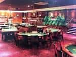 Interior del casino con mesas de juego y decoración moderna
