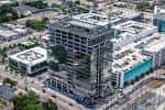 Vista aérea de la construcción de un rascacielos en Midtown Tampa rodeado de edificios existentes