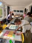 Interior del centro de arte mostrando un taller o exposición con personas trabajando en mesas