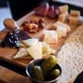 Detalle de tabla de quesos y aperitivos servida en el establecimiento