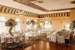 Salón de eventos del Italian Club de Tampa decorado para una boda con mesas redondas y arcos ornamentales