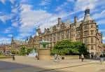 Vista exterior del Sheffield Town Hall con fachada victoriana y fuente en primer plano