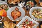 Mesa servida con diversos platos de comida italiana y bebidas
