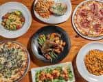 Vista cenital de una mesa con múltiples platos de pizza y pasta