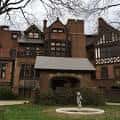 Fachada histórica del edificio principal con detalles arquitectónicos góticos y fuente frontal