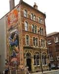 Fachada exterior del edificio del Brew Society con mural colorido en la pared lateral